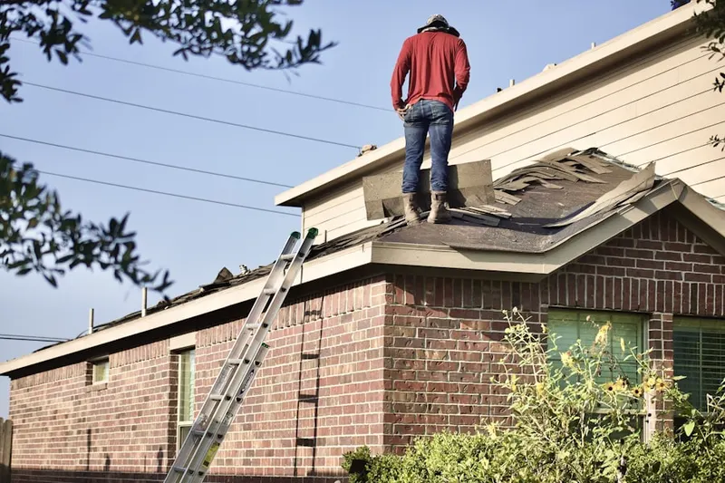 Professional roofer working on a residential roof in Van Raub